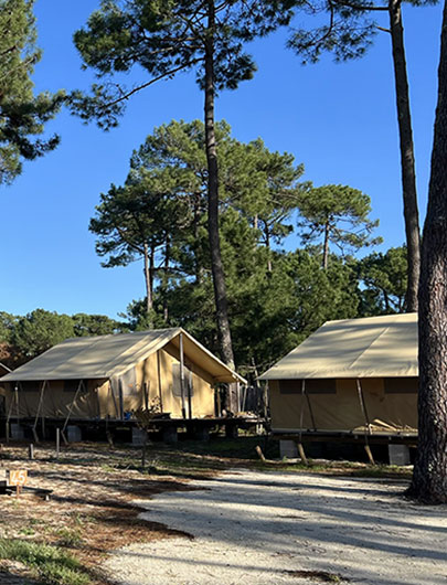 Location de tente lodge avec sanitaire, équipée d’une terrasse en bois de 42 m² sur pilotis. Hébergement insolite en Gironde au camping Montacabana à Montalivet